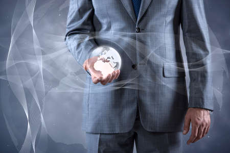 Businessman holding earth in global conceptの写真素材