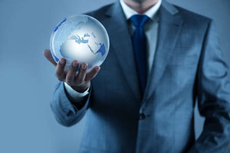 Businessman holding earth in global conceptの写真素材