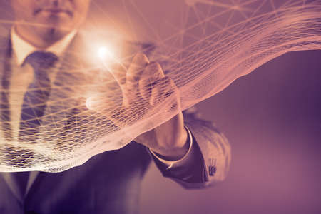 Businessman pressing virtual button in futuristic conceptの写真素材