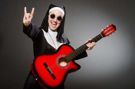 Funny nun with red guitar playingの写真素材