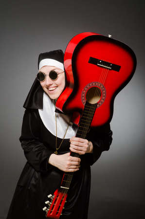 Funny nun with red guitar playingの写真素材