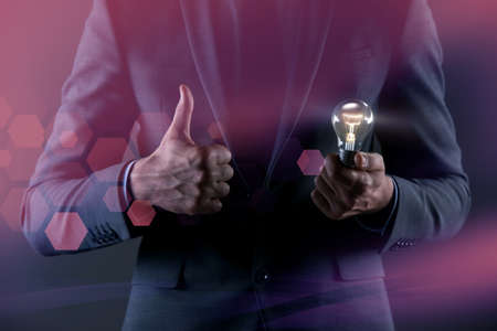 Man with light bulb lamp in conceptの写真素材