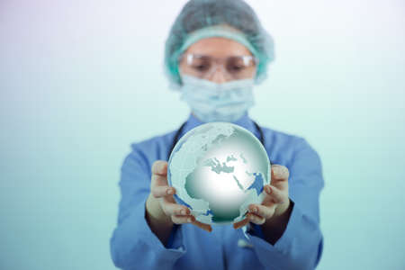 Woman doctor holding earth in globalisation conceptの写真素材