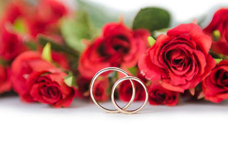 Wedding rings and flowers isolated on white backgroundの写真素材