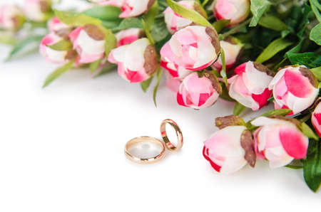 Wedding rings and flowers isolated on white backgroundの写真素材