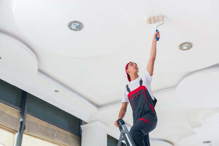 Young painter painting the ceiling in construction conceptの写真素材