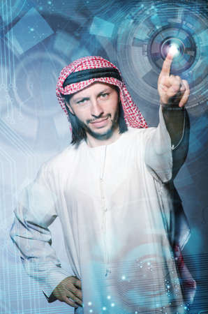 Arab man pressing virtual buttons in futuristic conceptの写真素材