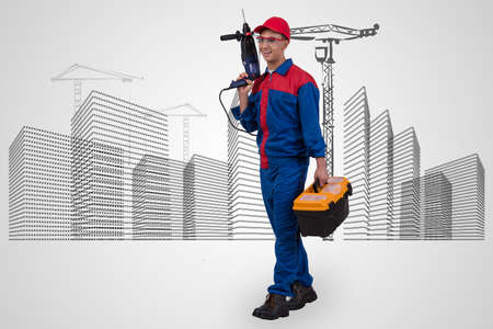 Man with drill against hand-drawn buildingsの写真素材