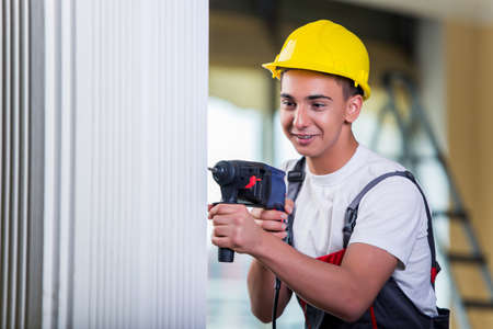 Man drilling the wall with drill perforatorの写真素材