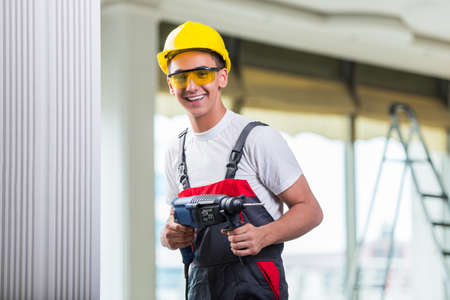 Man drilling the wall with drill perforatorの写真素材