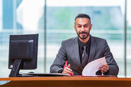 Happy businessman sitting at the desk