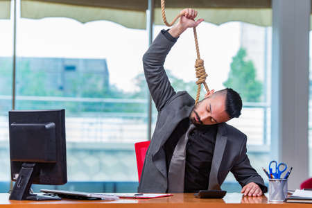 Concept of overworked businessman with noose around his neckの写真素材