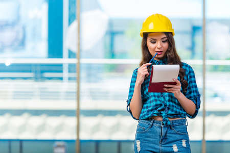 Woman builder taking notes at construction siteの写真素材