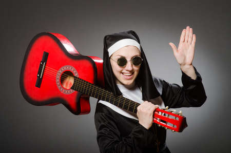 Funny nun with red guitar playingの写真素材