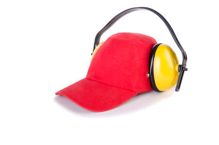 Red baseball cap with noise headphones isolated on whiteの写真素材