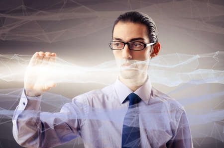 Businessman pressing virtual buttons in futuristic conceptの写真素材