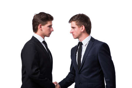 Two twin brothers handshaking isolated on whiteの写真素材
