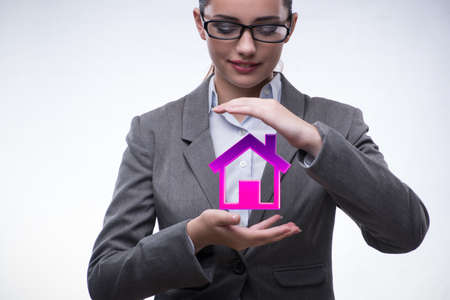 Young businesswoman holding house in real estate conceptの写真素材