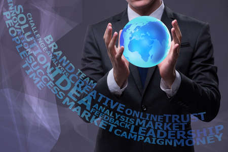 Young businessman in globalisation concept holding earthの写真素材
