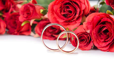 Wedding rings and flowers isolated on white backgroundの写真素材