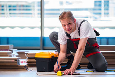 Man laying laminate flooring in construction conceptの写真素材