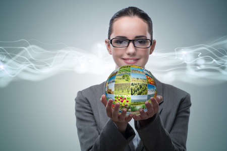 Businesswoman holding ball made of nature photosの写真素材