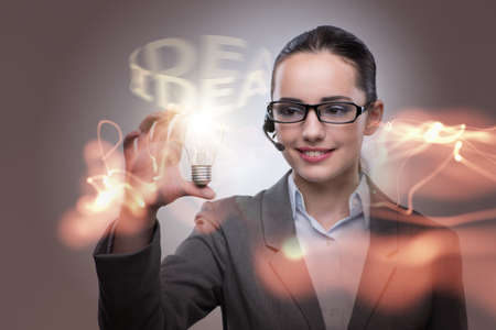 Young call center operator with bulb in idea conceptの写真素材