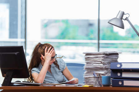 Stressed businesswoman with stack of papers