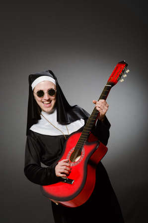 Funny nun with red guitar playingの写真素材