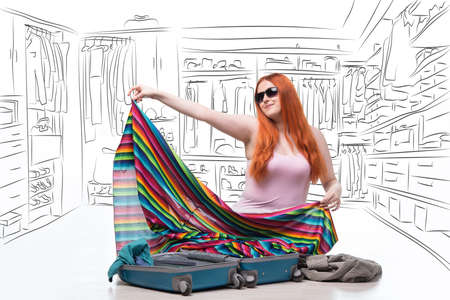 Redhead woman unpacking her clothing after vacationの写真素材