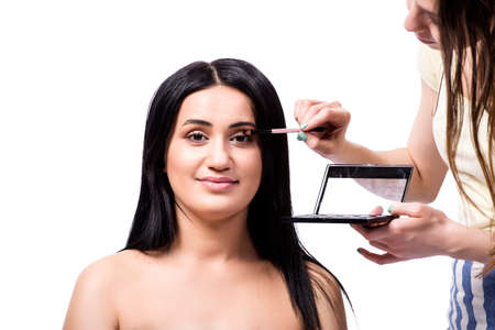 Young woman getting make-up isolated on white