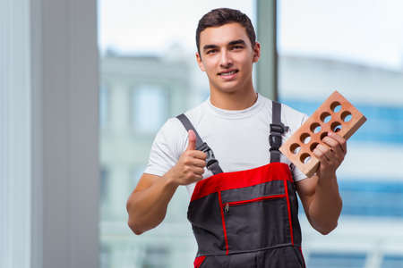 Young bricklayer working at construction siteの写真素材