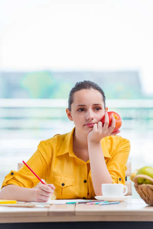 Young school gilr drawing pictures at homeの写真素材