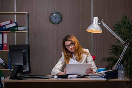 Businesswoman staying in the office for long hoursの写真素材