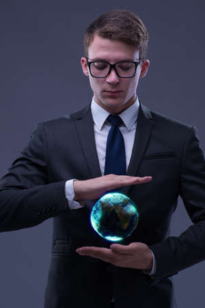 Young businessman in globalisation concept holding earthの写真素材