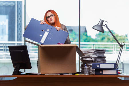 Red head woman moving to new office packing her belongingsの写真素材