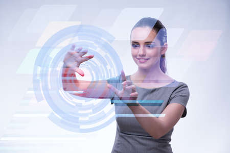 Businesswoman pressing virtual buttons in futuristic conceptの写真素材