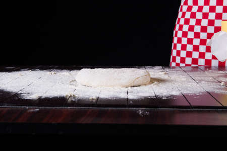 Cook preparing dough for baking in the kitchen