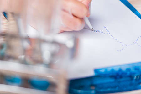 Young student working with chemical solutions in lab