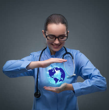 Woman doctor holding earth in globalisation conceptの写真素材