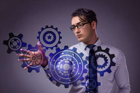 Businessman with cogwheels gear in teamwork conceptの写真素材