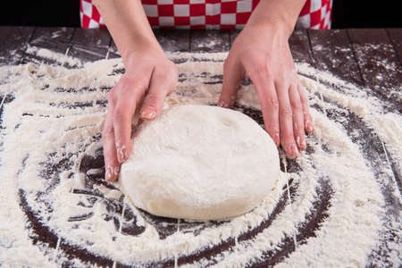 Cook preparing dough for baking in the kitchenの写真素材