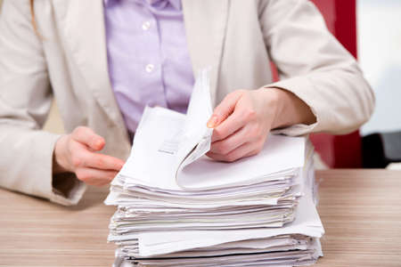 Businesswoman working with stack of papers