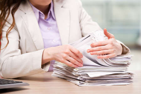 Businesswoman working with stack of papers