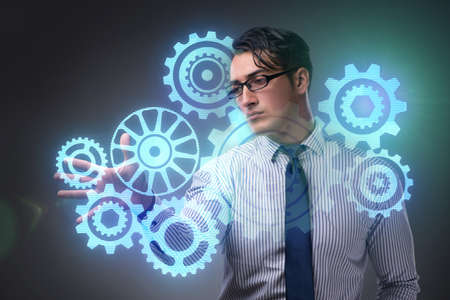 Businessman with cogwheels gear in teamwork conceptの写真素材