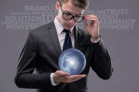 Young businessman in globalisation concept holding earth