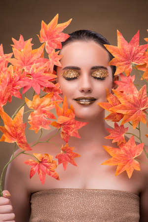 Young woman with dry autumn leavesの写真素材