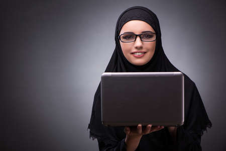 Muslim woman in black dress against dark backgroundの写真素材