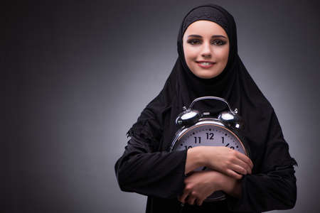 Muslim woman in black dress against dark backgroundの写真素材