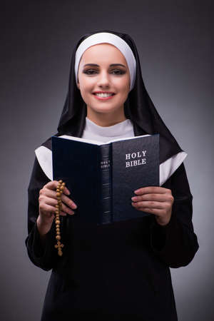 Religious nun in religion concept against dark backgroundの写真素材
